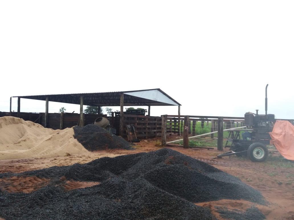 Covered commodity storage shed holding raw materials and machinery.