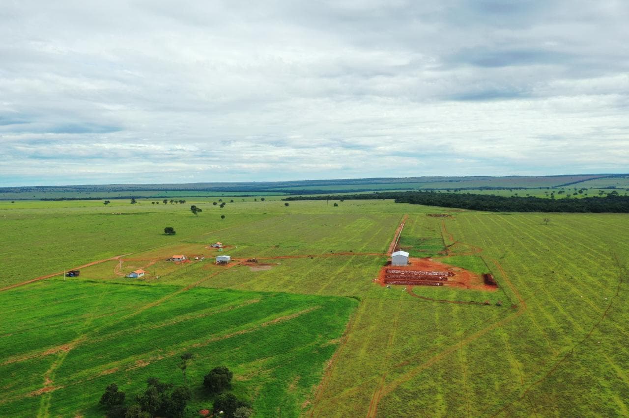 Vista aérea de drone da fazenda de pecuária mostrando pastagens, estradas internas e construções na propriedade.