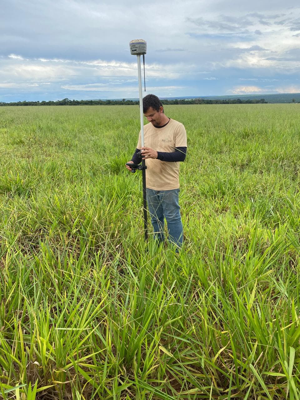 Técnico realizando levantamento topográfico com GNSS em campo antes do planejamento da infraestrutura.